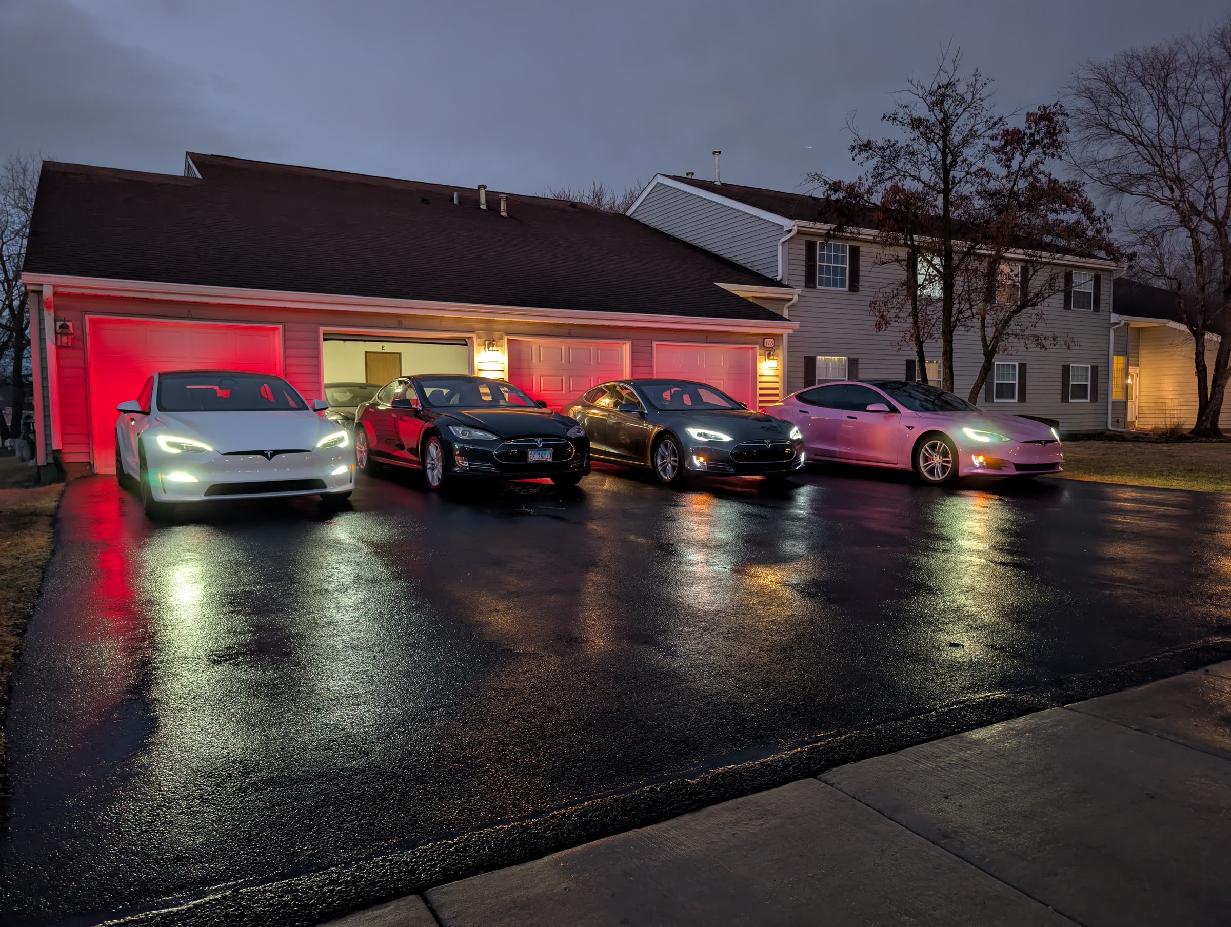 Four Tesla vehicles parked together in a driveway
